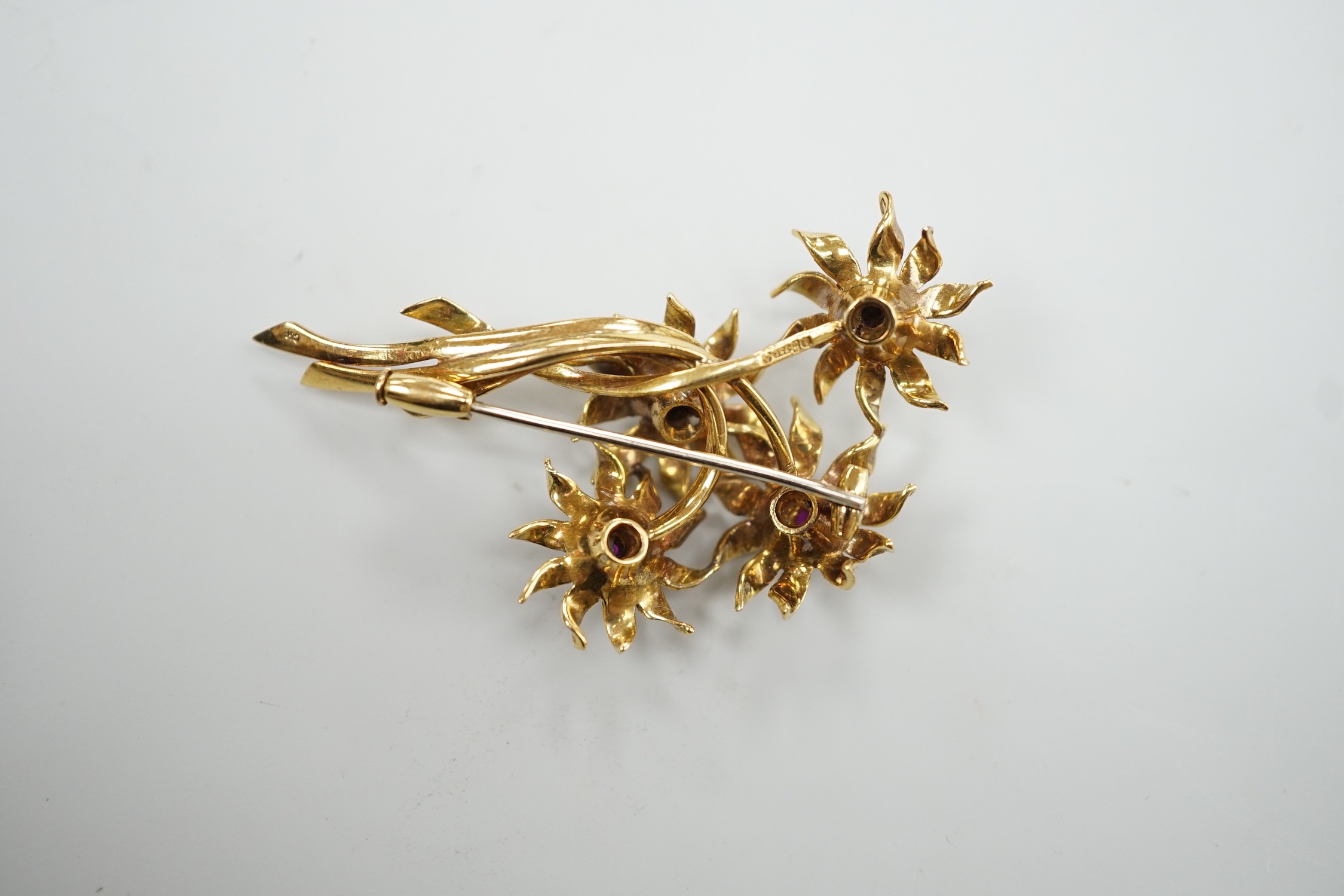 A 1960's 18ct gold and four stone ruby set floral spray brooch, 50mm
